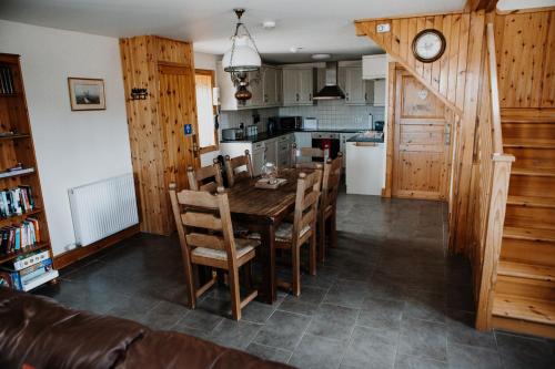 a kitchen and dining room with a wooden table and chairs at Deveron Valley Cottages in Marnoch