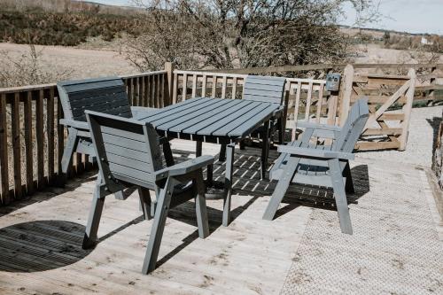 a picnic table and chairs on a wooden deck at Deveron Valley Cottages in Marnoch