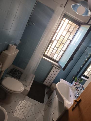a bathroom with a toilet and a sink and a window at Come a Casa in Caserta