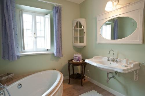 a bathroom with a tub and a sink and a mirror at LAVANDA appartamento in Vigliano Biellese