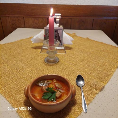 a candle and a bowl of soup next to a table at Hotel&Restaurant Gasthof zur Post Eisenerz in Eisenerz