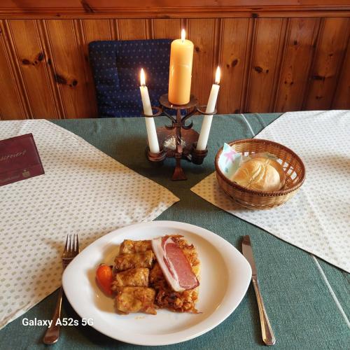 a plate of food on a table with candles at Hotel&Restaurant Gasthof zur Post Eisenerz in Eisenerz