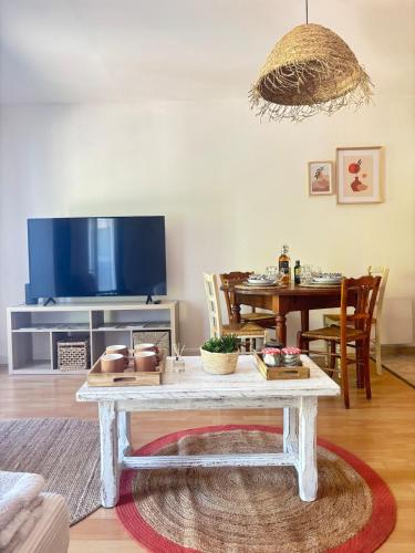 a living room with a table and a tv at Suite Aubenas centre - château in Aubenas