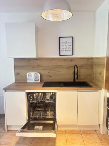 a kitchen with a sink and an oven at Suite Aubenas centre - château in Aubenas