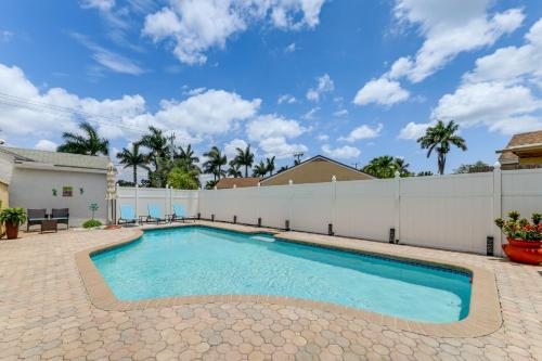 a swimming pool in a backyard with a white fence at Golf and Shop Gem with Private Pool in Boca Raton in Boca Raton