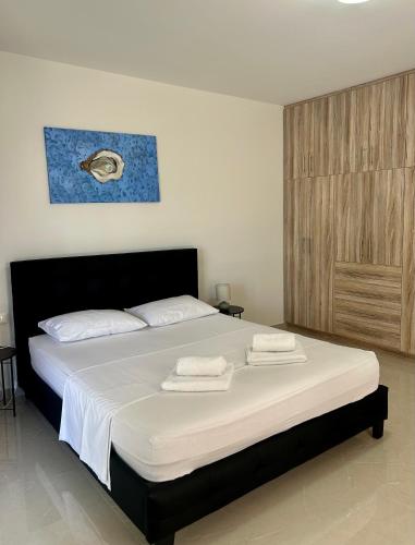 a bedroom with a large bed with towels on it at Cozy home next to Athens airport in Koropíon