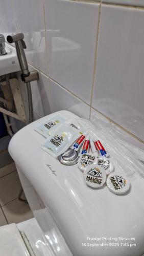 a white toilet in a bathroom with stickers on it at Mavriz Transient in La Trinidad