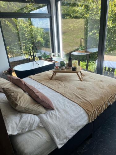 a bedroom with a bed with a bath tub and a window at Tea House Ponoarele in Ponoarele