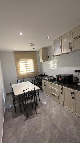 eine Küche mit einem Tisch und einem Tisch und Stühlen in der Unterkunft شقة الراحة in Tabuk