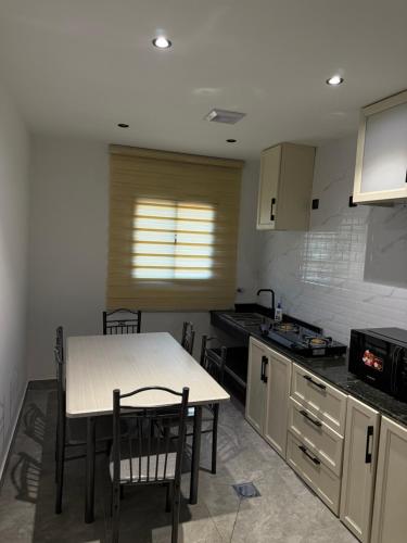 eine Küche mit einem Tisch und Stühlen in einer Küche in der Unterkunft شقة الراحة in Tabuk