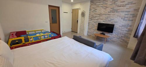 a bedroom with a bed and a tv and a brick wall at Q House in Puli