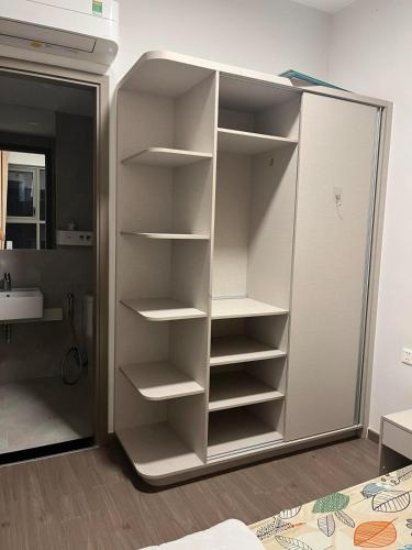 a closet with white shelves and a sink in a room at Mickey home's in Ho Chi Minh City