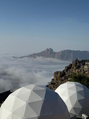 two white domes on top of a mountain with clouds at Grand canyon domes Jabal shams in Sa‘ab Banī Khamīs