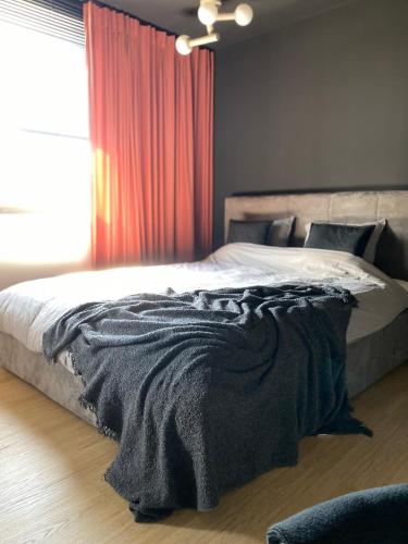 a bedroom with a bed with a blanket on it at Apartament Imperial Przedmieście in Grudziądz