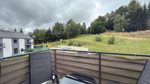 a balcony with a fence and a car on a road at Jeleń Residence in Jeleniów