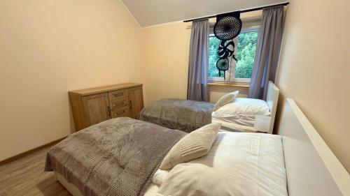 a bedroom with two beds and a window at Jeleń Residence in Jeleniów