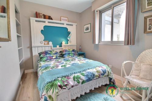 Un dormitorio con una cama y una silla y una ventana. en Villa kormoran, en Carnac