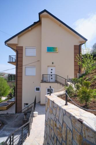 a building with a stone wall in front of it at Apartman Berlin Sokobanja in Soko Banja