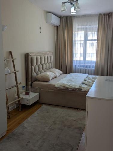 a bedroom with a large bed and a window at Moonflower residence 4645 in Bishkek