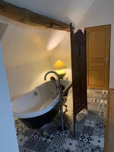 a bathroom with a bath tub in a room at Le relais de poste Valero in Serazereux