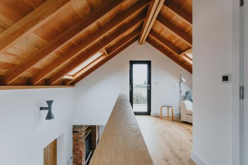 a living room with wooden ceilings and a fireplace at The Barn in Nottingham
