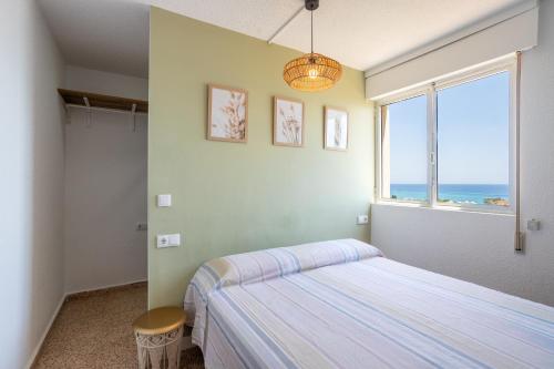 Un dormitorio con una cama y una ventana con el mar. en Paradise View, en Villajoyosa