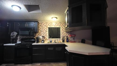 a kitchen with black cabinets and a white counter top at Faith short term rental in Romulus
