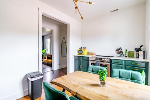 a kitchen with green cabinets and a wooden table at Prime Location Top Rated Clean Parking Free! in Chillicothe