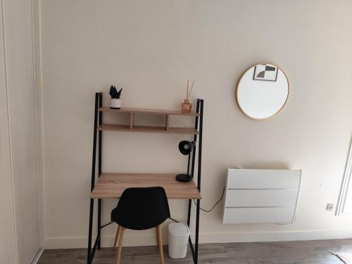 a desk and a chair in a room with a mirror at Chambre cosy et confort en centre ville in Evry-Courcouronnes
