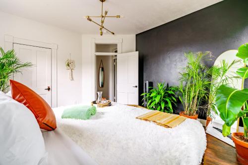 a bedroom with a large white bed with plants at Prime Location Top Rated Clean Parking Free! in Chillicothe