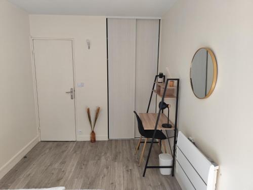 a room with a mirror and a table and a chair at Chambre cosy et confort en centre ville in Evry-Courcouronnes