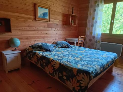 a bedroom with a bed in a wooden cabin at Maison chaleureuse en Ariège in Roquefort-les-Cascades