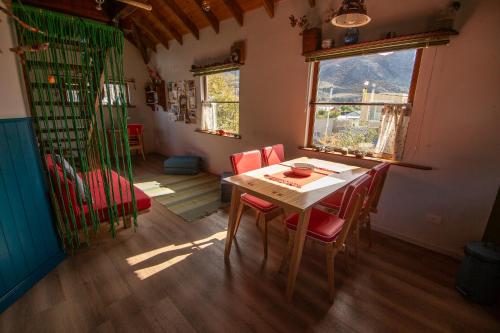 Un comedor con una mesa y sillas rojas. en CasaAndina Chalten, en El Chaltén