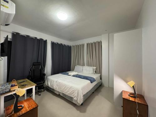 a bedroom with a bed and a desk with a computer at Oia in Moalboal