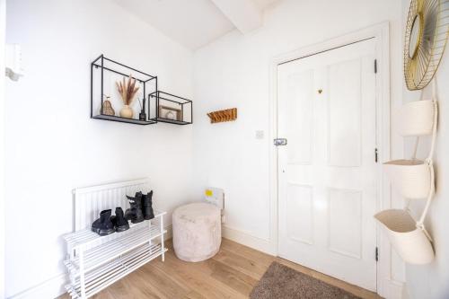 Chambre blanche avec une porte blanche et un tabouret dans l'établissement Stylish Stay Steps from Lively Docks, à Gloucester