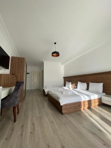 a bedroom with a large bed and a desk at Hotel Dardani in Mitrovicë
