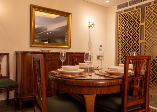 a dining room table with a mirror and wine glasses at Luxury Rooms in the Heart of Pyramids in Kafr Ghaţāţī