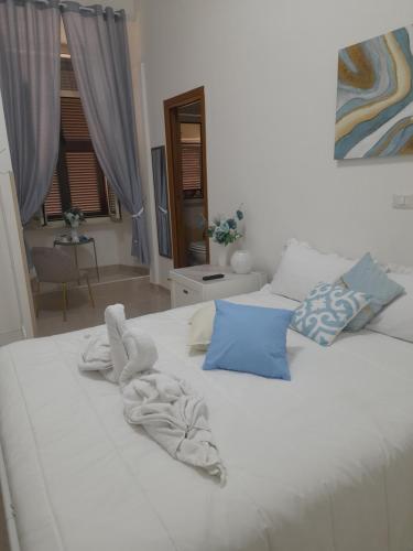 a white bed with towels on top of it at Falanga Family Guests Accommodation in Civitavecchia