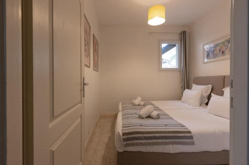 a bedroom with a bed with two stuffed animals on it at Hôtel Le Square in Saint-Pierre-dʼOléron