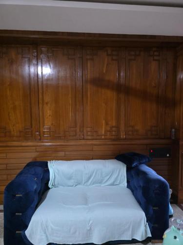 a bed in a room with a wooden wall at Mns residency in Imphal