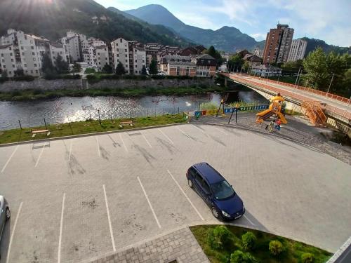 a car parked in a parking lot next to a river at Harmonija Priboj in Priboj