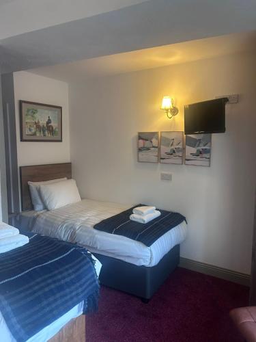a hotel room with two beds and a flat screen tv at Draper Rooms Galway in Galway