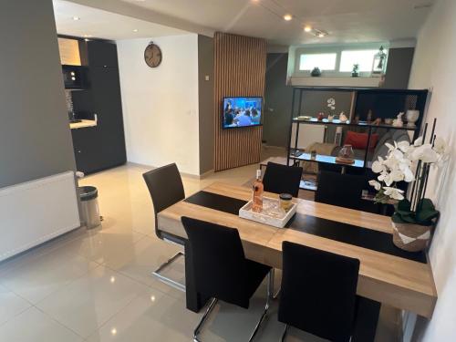 a dining room with a wooden table and black chairs at Chez Aneta in Sisteron