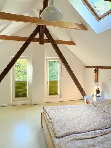 a bedroom with a bed and two windows at Remise an der Rennbahn - umzäuntes Anwesen mit Parkplätzen, AmzonPrime, Netflix, Wii, PS2 in Hoppegarten