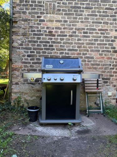 a stove sitting in front of a brick wall at Remise an der Rennbahn - umzäuntes Anwesen mit Parkplätzen, AmzonPrime, Netflix, Wii, PS2 in Hoppegarten