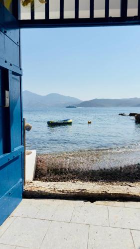 a blue door with a view of a body of water at Syrma Sunset Areti in Kástron