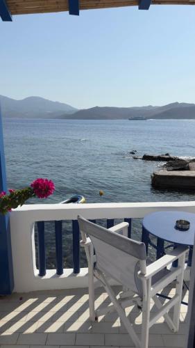 a white chair sitting on a porch overlooking the water at Syrma Sunset Areti in Kástron