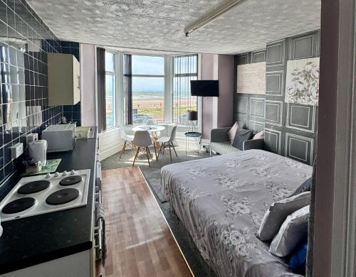 a bedroom with a bed and a kitchen and a living room at On The Beach Apartments in Blackpool