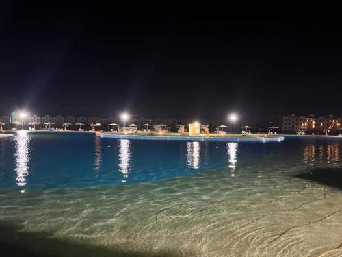 a large body of water at night with lights at شاليه ثلاث غرف مكيف ومجهز بالكامل in ‘Atāqah