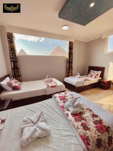 two beds in a room with a view of the pyramids at Comfort Inn Pyramids Hotel in Cairo